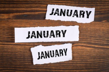 Ocak. Yeni yıl, planlar ve fırsatlar konsepti. Ahşap bir arka planda yırtık kağıtlar