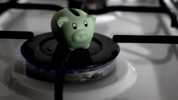 Aardgasprijzen, besparingen en begroting. Piggy bank op een gasfornuis — Stockvideo