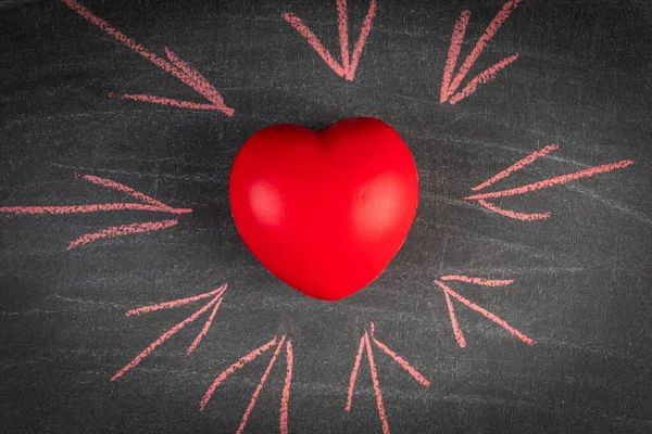 Heart health or love concept. Red rubber heart on a black chalk board — Stock Photo, Image