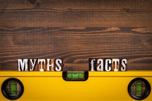 Myths and Facts Balance concept. Yellow spirit level on a wooden background — Foto Stock