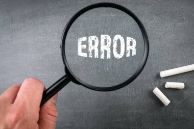 Hata konsepti. Bir erkeğin elinde büyüteç. tebeşir tahtası arkaplanı