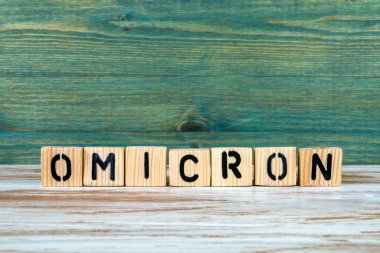 OMICRON. Beyaz ve yeşil ahşap arka planda harfler