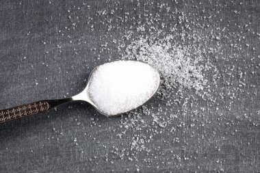 Beyaz şekerli çay kaşığı. Tebeşir tahtası arka planına dökülmüş