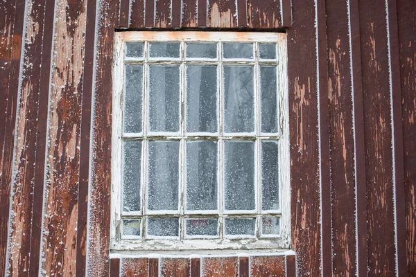Zasněžené staré okno. Exteriér dřevěné budovy — Stock fotografie