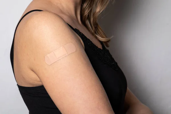 Vaccinatie op een vrouwenschouder. Medische pleister op de huid — Stockfoto