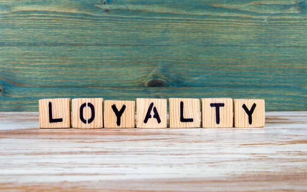 Loyalität. Text aus Holzblöcken auf weißem und grünem Hintergrund — Stockfoto
