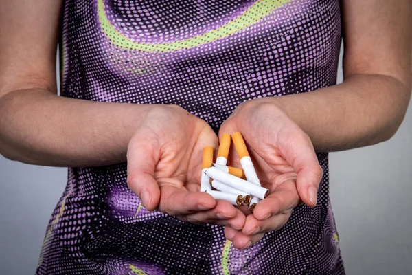 Бросай курить. Сломанные сигареты в женских руках. Новое начало и понятие здорового образа жизни — стоковое фото
