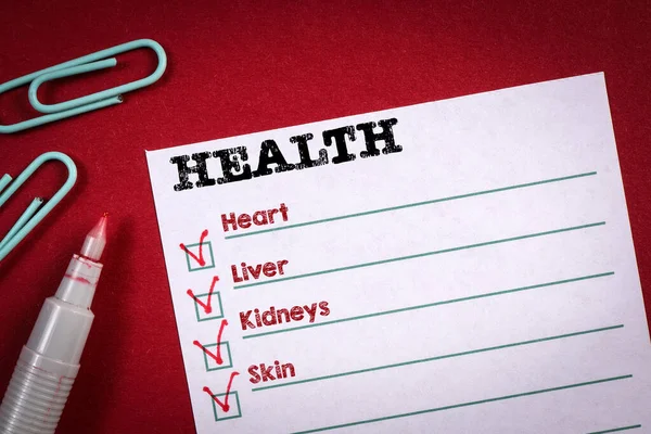 Lista de verificação de saúde. Nota folha e caneta vermelha na mesa — Fotografia de Stock