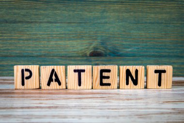 Patent. Tahta doku arkaplanındaki alfabe bloklarından metin