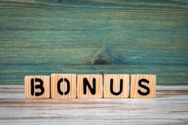 İkramiye. Yeşil ahşap arka planda alfabe bloklarından kelimeler