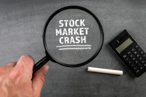 Crash del mercato azionario. Lente d'ingrandimento e calcolatrice su sfondo lavagna — Foto Stock