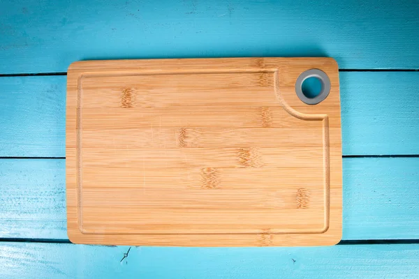 Mavi ahşap arka planda bambu kesme tahtası — Stok fotoğraf