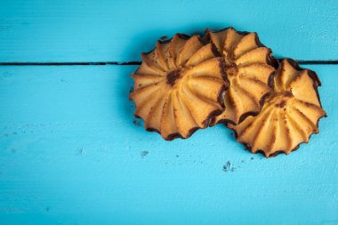 Mavi ahşap bir masada çikolata kremalı kurabiyeler