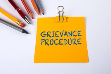 Sarı kağıt parçasına GRIEVANS PROCEDURE 'i yaz. Beyaz ofis masası