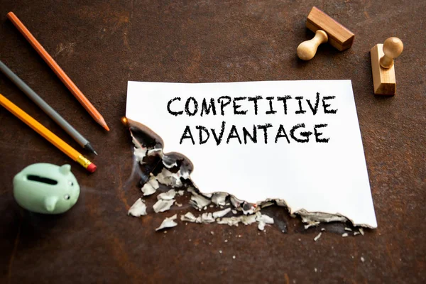 Rekabetçi avantaj. Paslı metal zemin üzerinde metin olan kağıt sayfaları yakılıyor