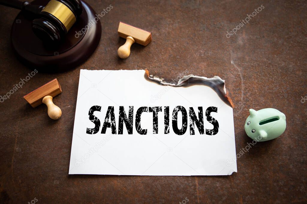 Sanctions. Judges hammer and a piggy bank on a rusty metal background