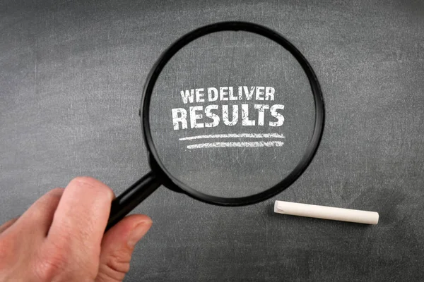 We Deliver Results. Text on a dark chalkboard background — Stok fotoğraf