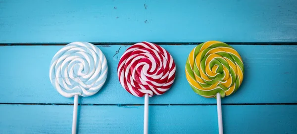 Colorful lollipops on a blue painted wooden background — Stock Photo, Image