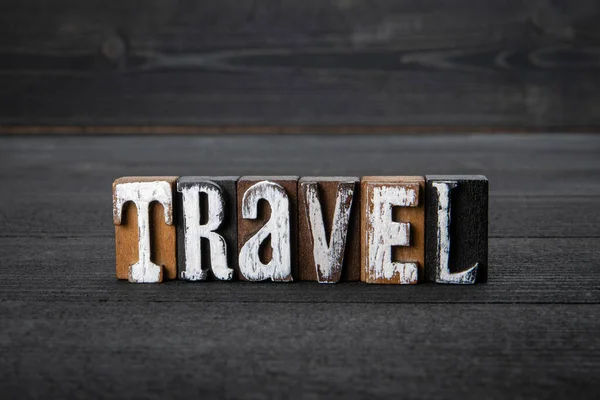 TRAVEL. Word from wooden alphabet blocks on a dark background — Foto Stock