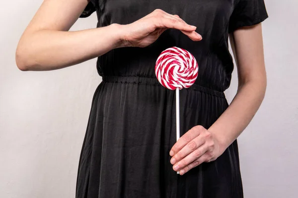 Womens health and hygiene. Holding red candy on a stick — стоковое фото