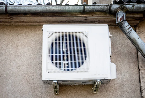 Air source heat pump, outdoor unit attached to the house wall