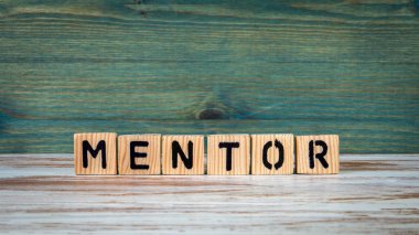 MENTOR konsepti. Yeşil ve beyaz arkaplandaki tahta alfabeden metin.