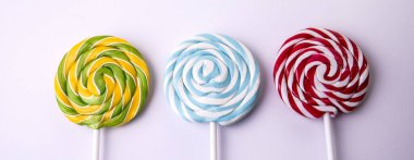 Beyaz arka planda üç lolipop. Yatay Pankart.