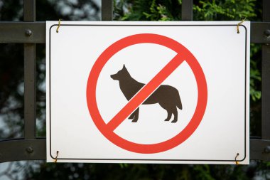 Dogs are not allowed to sign on a fence.