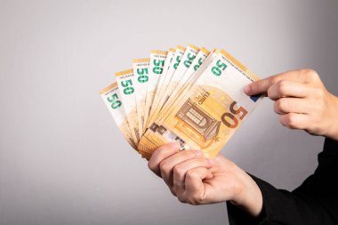 Euro banknotes in the hands of a woman. Counts money.