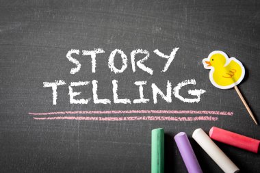 Hikaye anlatmak. Tahtadaki yazı ve renkli tebeşir parçaları.