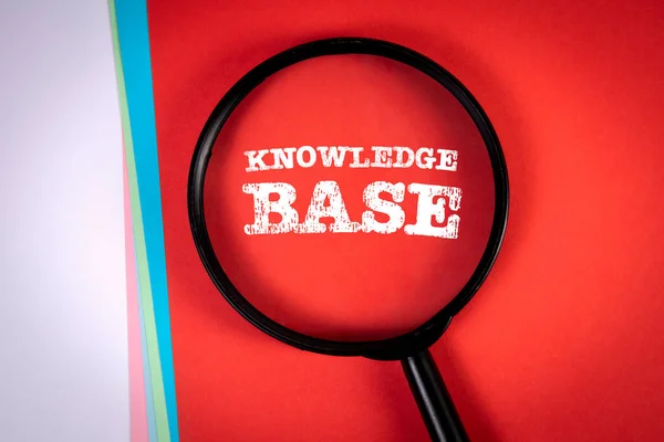 Knowledge base. Search and research concept. Magnifying glass on a red background.