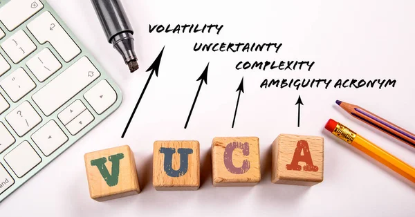 VUCA - Volatility Uncertainty Complexity Ambiguity acronym. White office desk.