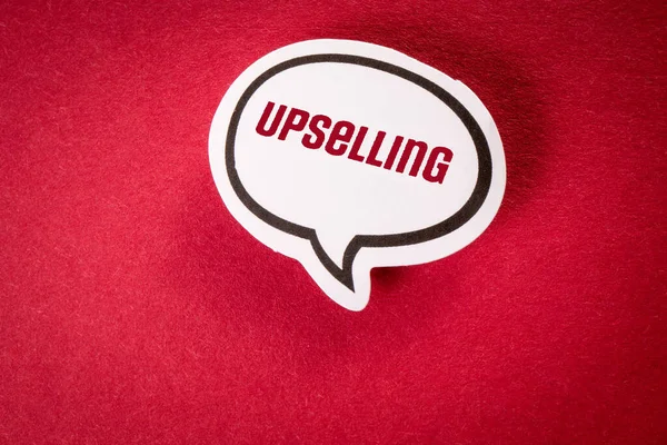 Upselling. White speech bubble with text on red background.