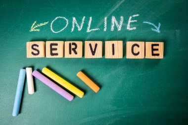 Online Service. Text. wooden alphabet letters on a green chalkboard.