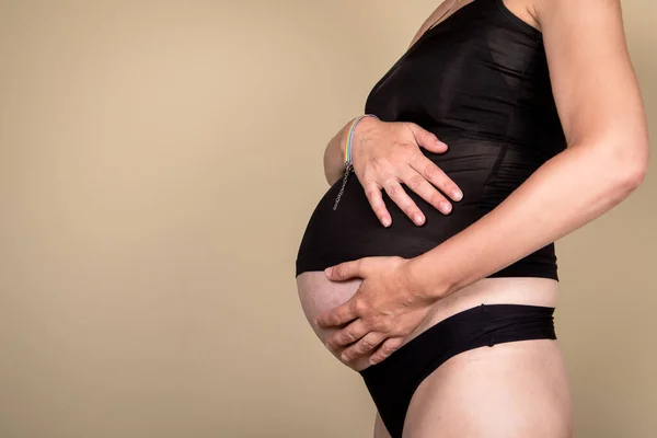 Pregnant woman, hands on stomach. Love and family concept.