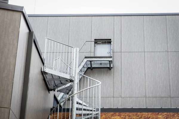 Security exit. Metal doors and stairs. Building facade and architecture.