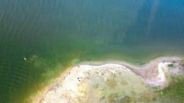 Sabahın erken saatlerinde Amerika, Teksas 'taki Lavon Gölü' nde balıkçıların 90 derecelik hava görüntüsü. Üst manzara sakin su ve kumlu kayalık balıkçılık yeri.