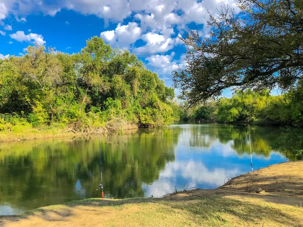 Bank fiske rad poler på spiral stång hållare stå på Denton Creek Trinity River nära Dallas, Texas, USA — Stockfoto