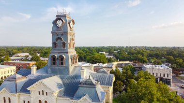 Aerial view close up the Clock Tower on top of Hood County Courthouse in Historic Granbury Square, Texas, America. Traditional landmarks surrounded by unique boutiques, restaurants, bistro clipart
