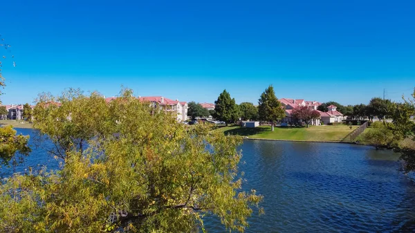 Dallas, Teksas, Amerika yakınlarındaki göl manzaralı apartman. Yeni liman bölgesi kiralık mülkler. Güneşli, açık mavi gökyüzü altındaki çok katlı binalar.