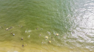 Çocuklar ve yetişkinler, Granbury, Teksas 'taki City Beach Park' ta yüzüyor ve yüzüyorlar. Hava ailesi plajda sakin dalgalar ve güvenli şamandıra hattıyla yaz tatili aktivitelerinin tadını çıkarıyor.