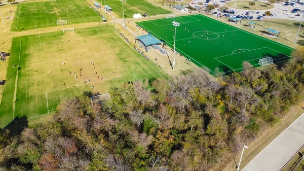 テキサス州ダラス近郊のスポーツ複合施設で開催されるエアビューユースサッカートーナメント 複数の自然と人工のフィールド郊外のチームスポーツ公園施設を実行している選手と — ストック写真