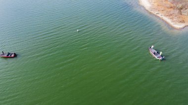 Güvenlik işaretleri olan büyük göl ve motorlu teknelerden avlanan balıkçılar Murrell Park, Grapevine Gölü, ABD