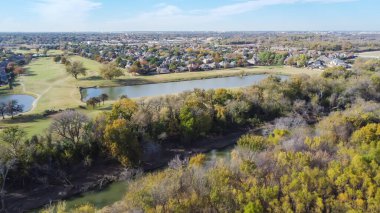 Hava manzaralı golf sahası ve sonbahar yeşillikleri ve deresi olan doğa parkına yakın yerleşim yerleri. Renkli sonbahar yaprakları ve Dallas şehir merkezi, Teksas