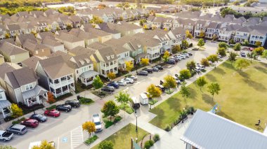 Tarihi Coppell, Teksas, ABD yakınlarında halka açık bir sanat tesisi olan parkın yakınındaki kasaba evi tarzı evler. Bahçesi olmayan lüks evler, güzel sonbahar yaprakları.