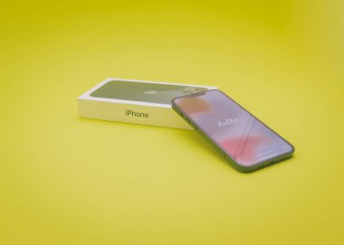 COPPELL, TX, USA-JAN 4, 2022: Hello kısa mesaj ekranlı Apple box ve iPhone 13. Yeni gece yarısı renginde yepyeni iPhone sarı arkaplanda izole edildi.