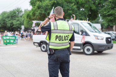 4 Temmuz 'da Dallas, Teksas, Amerika yakınlarındaki resmi geçit törenindeki polis memurunun arka görüntüsü. Festivalde kolluk kuvvetleri ve güvenlik görevlisi.