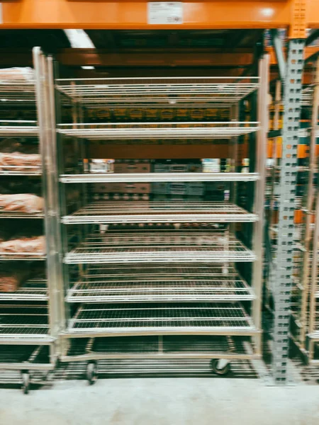 米国テキサス州ダラス近くの卸売店で ぼんやりとした空の棚の写真 食料不足とサプライチェーンの危機のためにホイールキャスター付きの空のスチールシェルフを持つスーパーマーケット — ストック写真