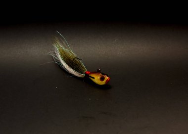 One bucktail Jig head lure hand tie deer hair fishing jig hooks isolated on black background. clipart