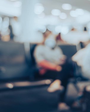 Tonlu fotoğraf hareketi maskeli yolcuyu bulanıklaştırdı. Los Angeles havaalanı, CA, ABD terminali kapısında bekliyor. Koltukta oturan gezginler covid-19 koronavirüs salgını için güvenlik önlemleri aldılar.